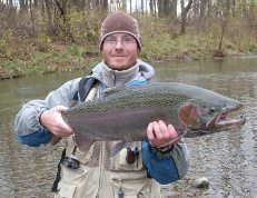 Angler with colorful male steelhead caught on Canadaway Creek